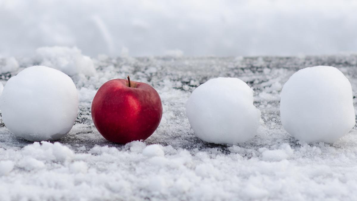 A snowball, a red apple and two more snowballs in a row.